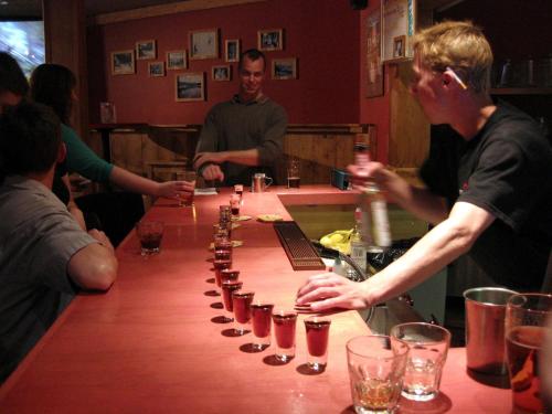 a group of people sitting around a bar with a drink at HI Banff Alpine Centre - Hostel in Banff