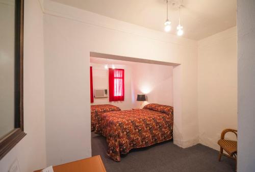 a bedroom with two beds and a red window at Amargosa Opera House & Hotel in Death Valley Junction