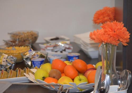 a table with a bowl of fruit and a vase with flowers at Hotel Peregrin in Český Krumlov