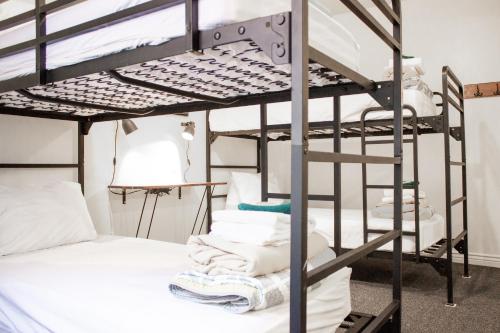 a room with bunk beds with white pillows and towels at 11th Avenue Hostel in Denver