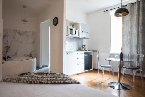 a bedroom with a bed and a table and a kitchen at Pink Intimate Jacuzzi Suite Trastevere - Top Collection in Rome