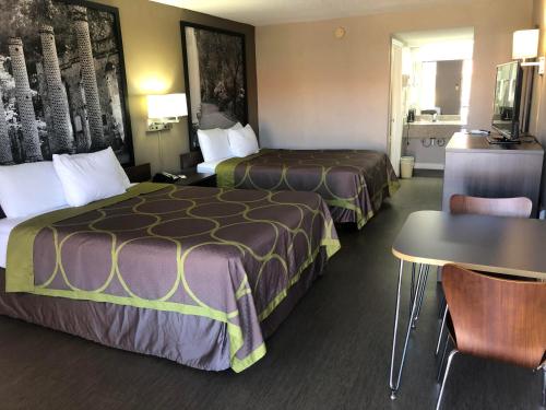 a hotel room with two beds and a table at Super 8 by Wyndham Orangeburg Near I-26 in Orangeburg