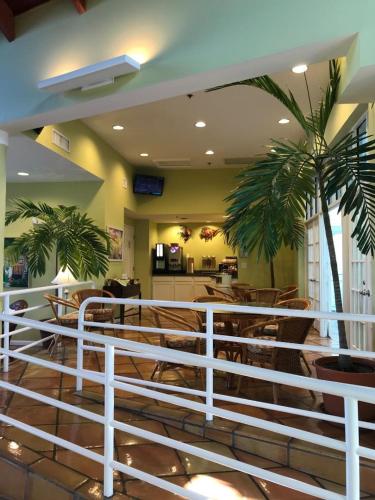 a restaurant with a white fence and palm trees at Jupiter Waterfront Inn in Jupiter
