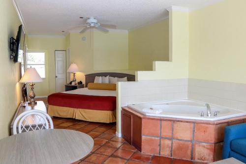 a hotel room with a bed and a bath tub at Jupiter Waterfront Inn in Jupiter