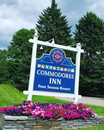 a sign for a community computers inn with flowers at Commodores Inn in Stowe