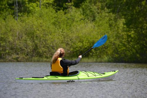 a woman sitting on a kayak in the water at Commodores Inn in Stowe