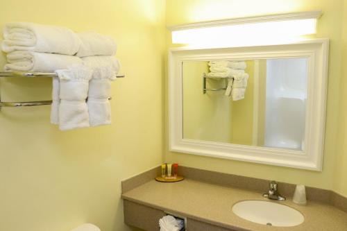 a bathroom with a sink and a mirror and towels at Jupiter Waterfront Inn in Jupiter