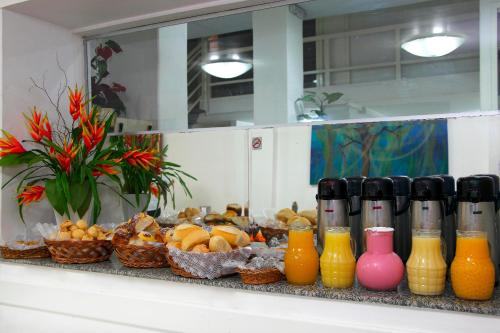 a shelf with vases and baskets of fruit and juice at Hotel Pampulha Palace in Belo Horizonte