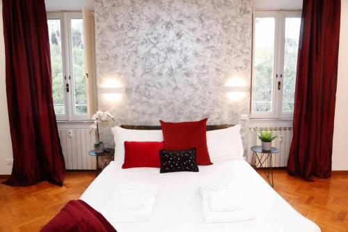 1 dormitorio con 1 cama blanca grande con almohadas rojas en Black Enchanting Jacuzzi Suite Trastevere - Top Collection, en Roma