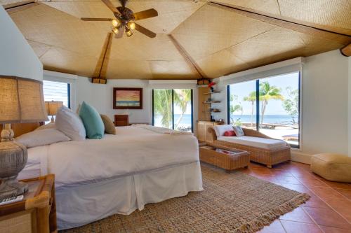 a bedroom with a large bed with a ceiling fan at Royal Belize in Dangriga