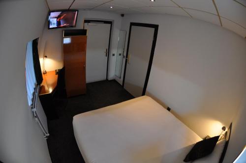 a small room with a bed and a tv at Budget Hotel Le Beau Rivage in Middelburg