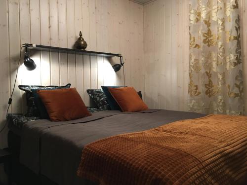 a bedroom with a large bed with orange pillows at Casino Islands Getaway in Savonlinna