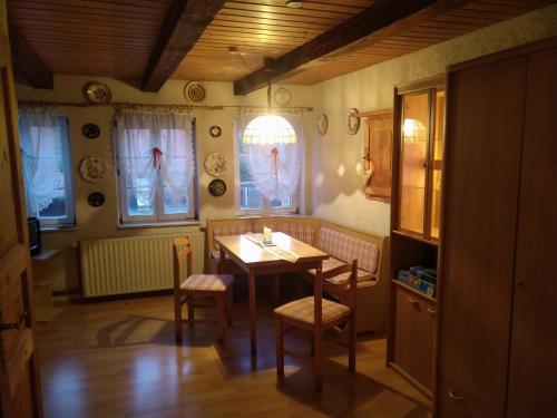 uma sala de jantar com mesa, cadeiras e janelas em Ferienhaus Börsengasse 1 em Duderstadt