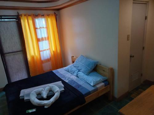 Un pequeño dormitorio con una cama con toallas. en Trekkers Lodge and Cafe, en Banaue