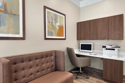 a room with a desk with a computer and a chair at Days Inn by Wyndham Beaumont West I-10 Walden in Beaumont