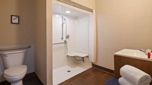 y baño con ducha, aseo y lavamanos. en SureStay Plus by Best Western San Antonio Fort Sam Houston, en San Antonio
