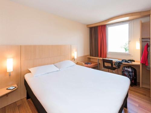 Un pat sau paturi într-o cameră la ibis Montbéliard