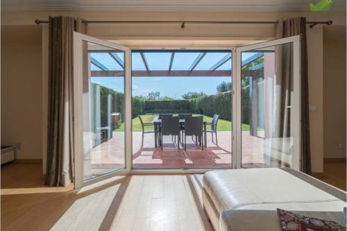 a living room with a large sliding glass door with a dining table at Sunset House Cascais in Cascais