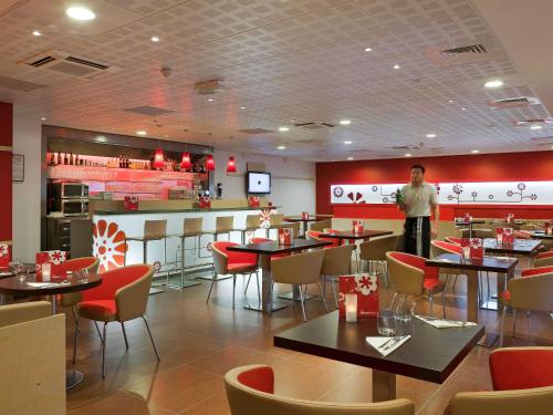 a restaurant with tables and chairs in it at ibis Paris Montmartre 18ème in Paris
