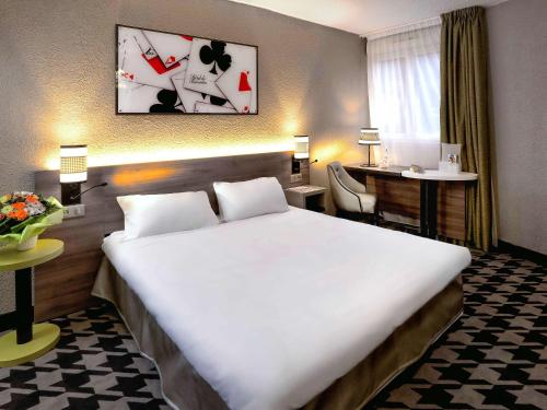 Pokój hotelowy z dużym łóżkiem i biurkiem w obiekcie ibis Styles Rouen Nord-Barentin w mieście Barentin