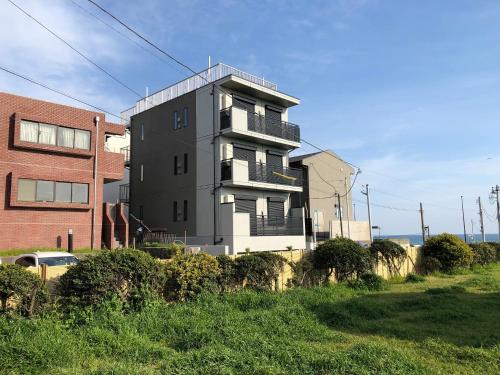 a tall building in the middle of a field at Purpose Resort Ocean View Kamakura in Kamakura
