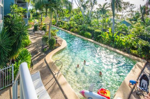 a swimming pool with people in the water at a resort at Blue Water Views on Hamilton Island by HIHA in Hamilton Island
