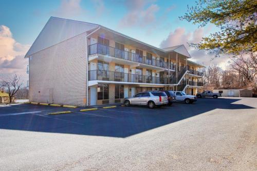 a large building with cars parked in a parking lot at APM Inn and Suites in Winchester