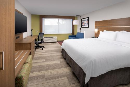Holiday Inn Express Atlanta SW - Newnan, an IHG Hotel في نيونان: غرفة فندقية بسرير وتلفزيون بشاشة مسطحة