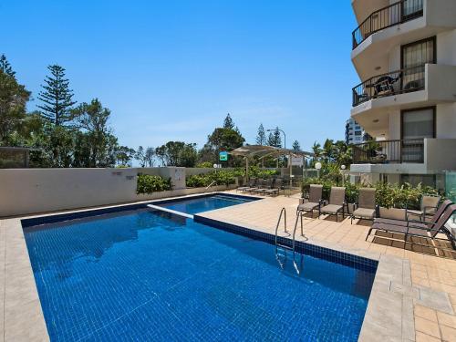 a swimming pool in front of a building at Seaview Resort in Mooloolaba