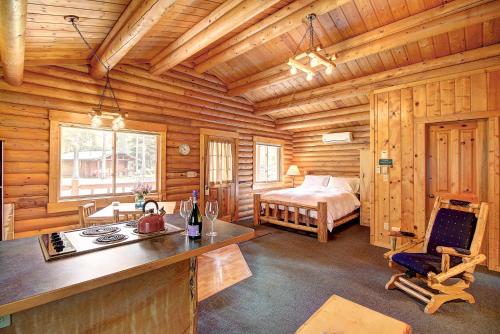 a log cabin kitchen with a bed in the background at North Forty Resort in Columbia Falls