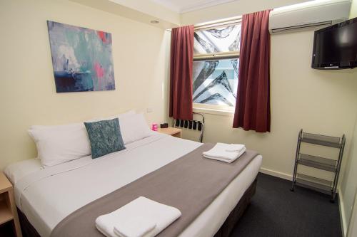 فندق ميامي ملبورن في ملبورن: غرفة نوم عليها سرير وفوط