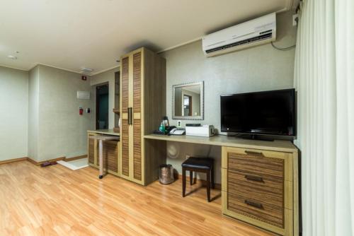 a room with a desk with a television and a deskictericter at Residence Hotel Lamia in Daejeon