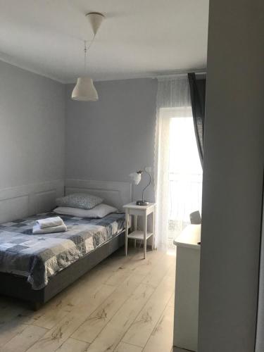 1 dormitorio con cama, mesa y ventana en Szafranówka en Władysławowo