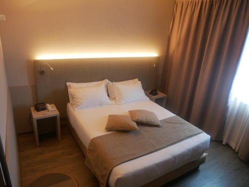 a bedroom with a bed with two pillows on it at First Hotel Malpensa in Case Nuove