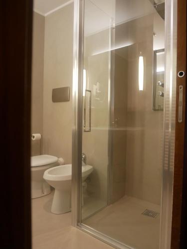 
a bathroom with a toilet, sink, and shower at First Hotel Malpensa in Case Nuove
