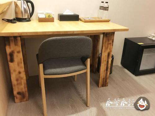 a wooden table with a chair in a room at 沐馨溫泉民宿 in Jiaoxi