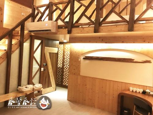 a room with a large door in a wooden building at 沐馨溫泉民宿 in Jiaoxi