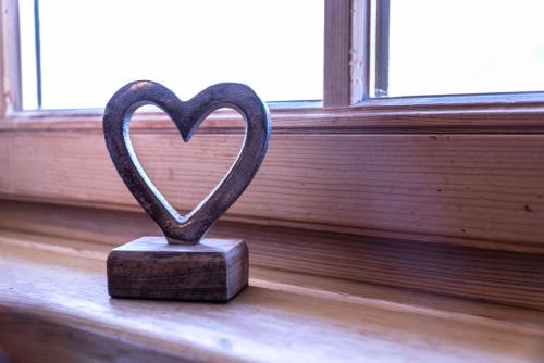 a heart statue sitting in front of a window at Apartmenthaus Edelweiss in Gosau in Gosau