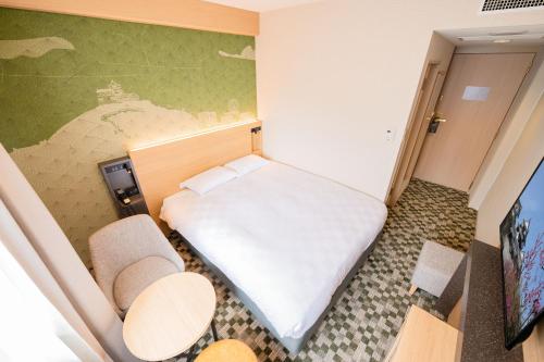 a small room with a bed and a tv at Matsuyama Tokyu REI Hotel in Matsuyama