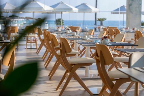 a row of tables and chairs in a restaurant at Infinity Blu - Designed for Adults by Louis Hotels in Protaras