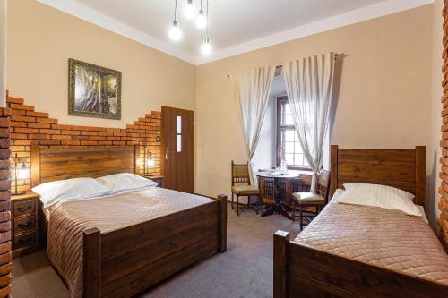 a bedroom with two beds and a desk at Zamek Czocha in Leśna