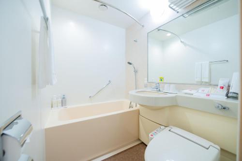 a bathroom with a toilet and a sink and a mirror at Matsuyama Tokyu REI Hotel in Matsuyama