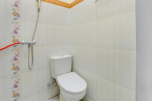 a bathroom with a toilet and a shower at OYO 3074 Orange Inn in Madiun