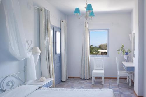 1 dormitorio con cama, mesa y ventana en Atlantis Beach Villa, en Perivolos