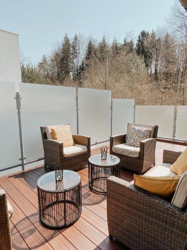 a patio with chairs and tables on a deck at Lake View Apartment Seecorso in Velden am Wörthersee