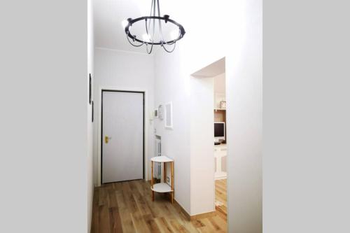 Habitación con pasillo con mesa y lámpara de araña. en Delizioso appartamento cosy ristrutturato en Parma