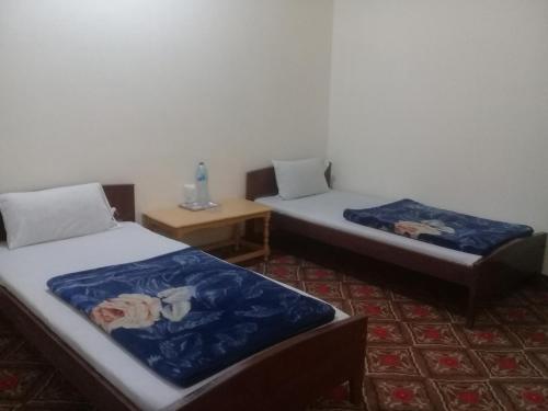um quarto com duas camas e uma mesa em Benazir Hotel Kalash 