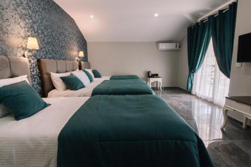 two beds in a hotel room with green covers at Melrose House Hotel in Pamukkale