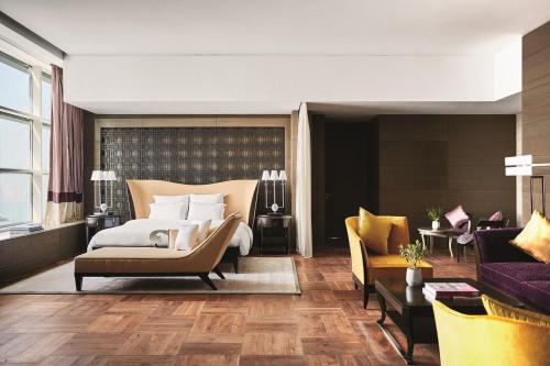 a hotel room with a bed and a couch at Pullman Doha West Bay in Doha