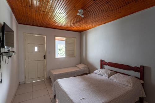 1 dormitorio con 2 camas y techo de madera en Pousada Barão do Javary, en Miguel Pereira